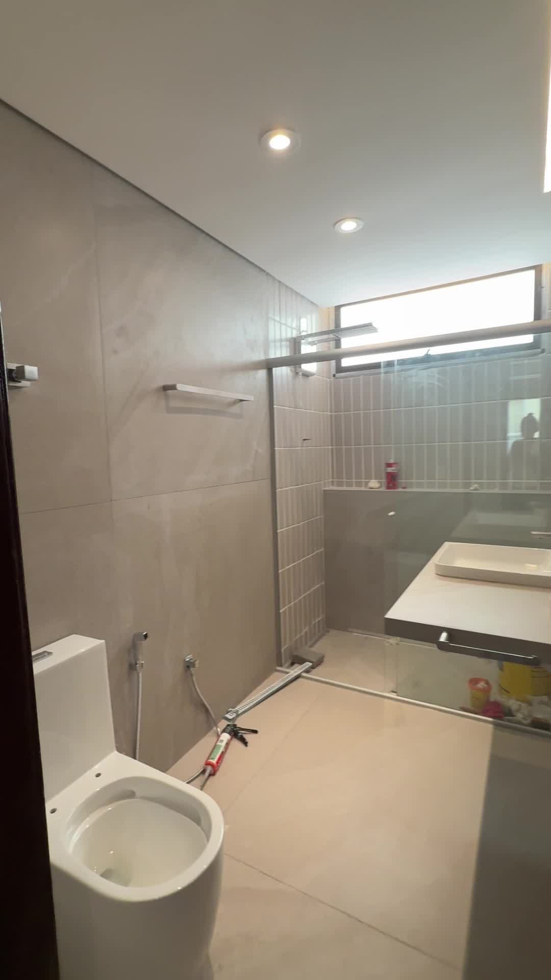 Banheiro com porcelanato de grande formato, faixa em pastilha vertical no box e ralo linear, obra da Apus Construtora