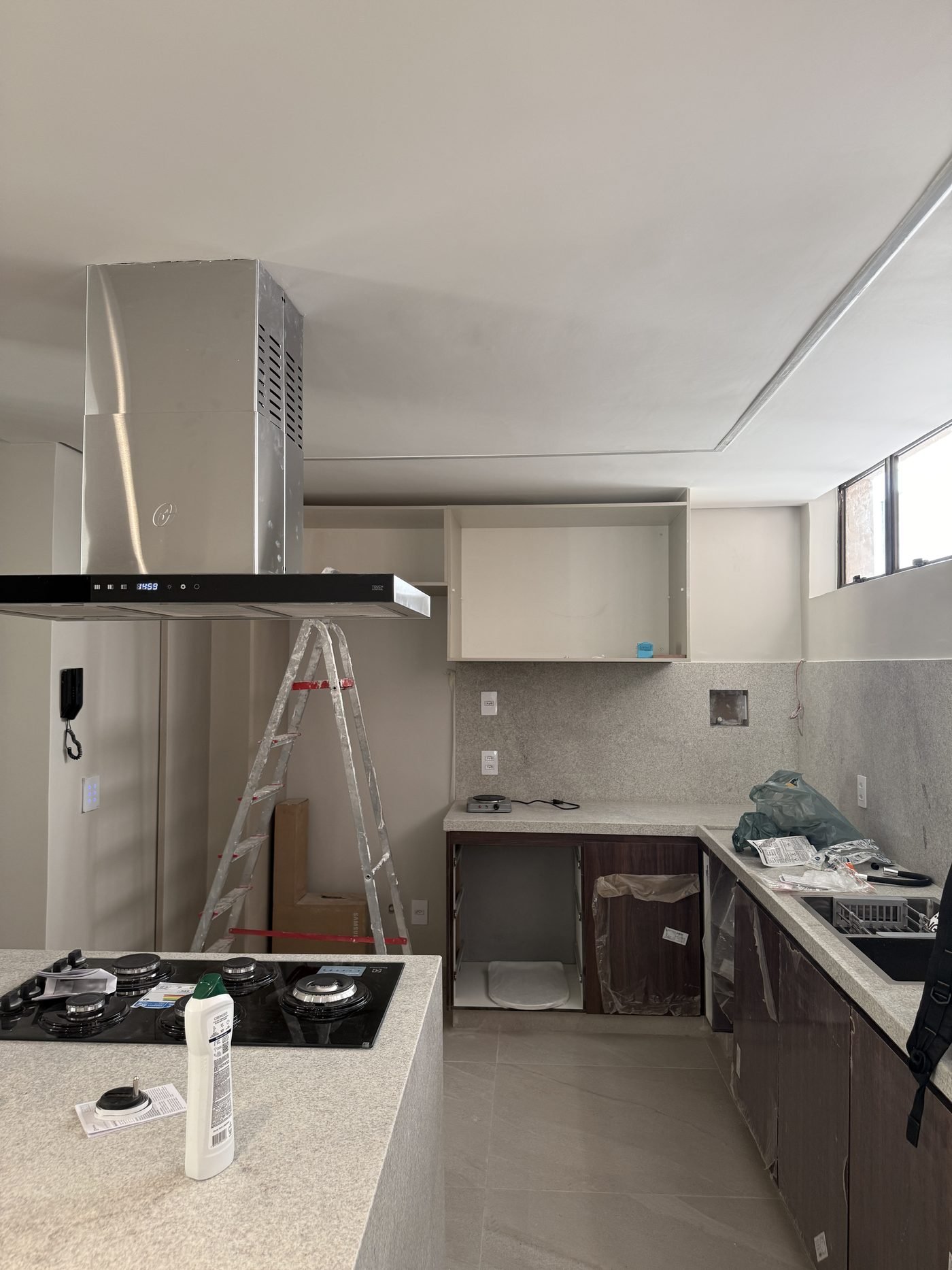 Cozinha de apartamento na região centro-sul de Belo Horizonte com bancada em granito e coifa de ilha