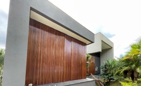 Detalhe de brise de madeira e beiral em concreto na fachada de residência de alto luxo, obra da Apus Construtora