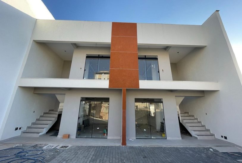 Fachada de duas casas de 130 metros quadrados em Contagem com painel central em revestimento diferenciado, executadas pela Apus Construtora
