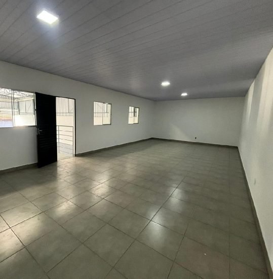 Área administrativa interna do galpão, com piso cerâmico e iluminação embutida