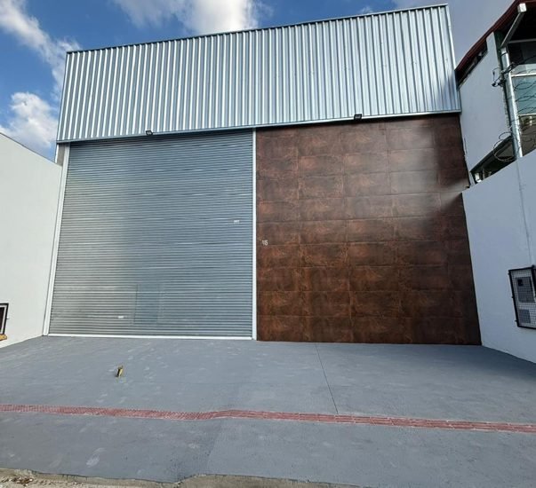 Fachada de galpão de 330 metros quadrados em Belo Horizonte, com portão de enrolar para carga e descarga, executado pela Apus Construtora