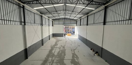 Vista interna do galpão em direção ao acesso de veículos
