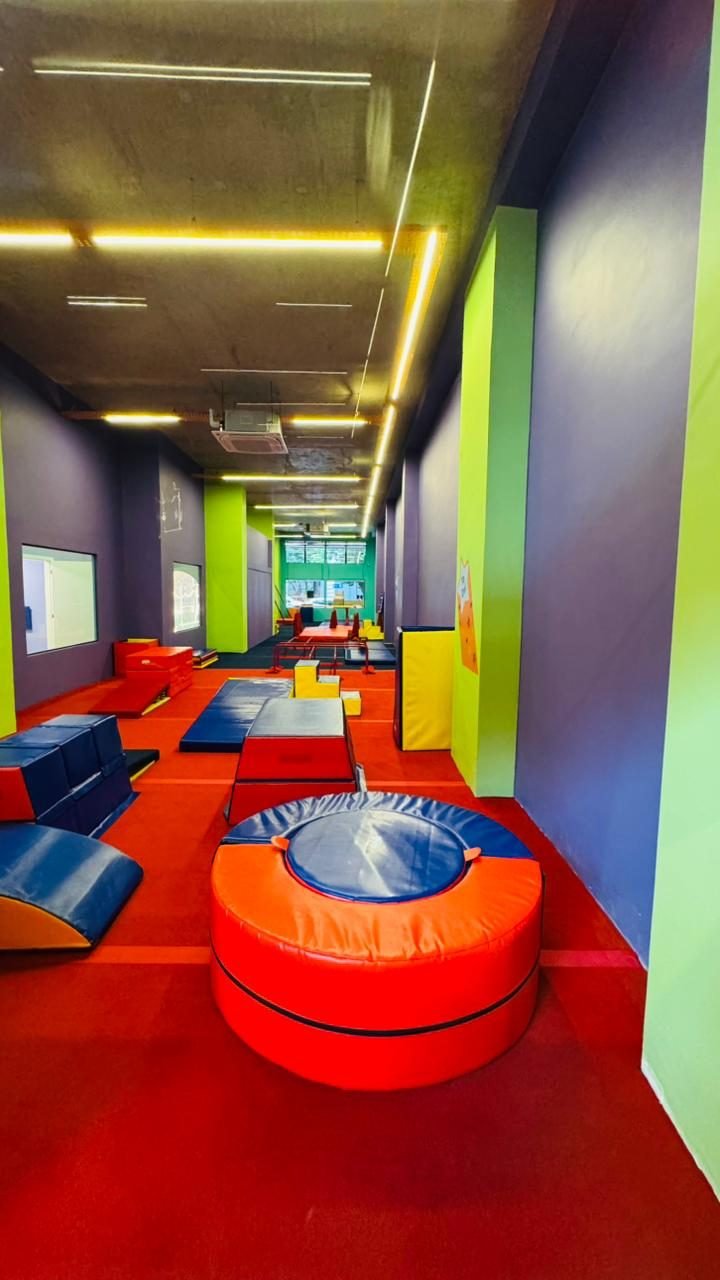 Área de atividades da loja comercial na Savassi, com piso emborrachado e paginação de cores nas paredes